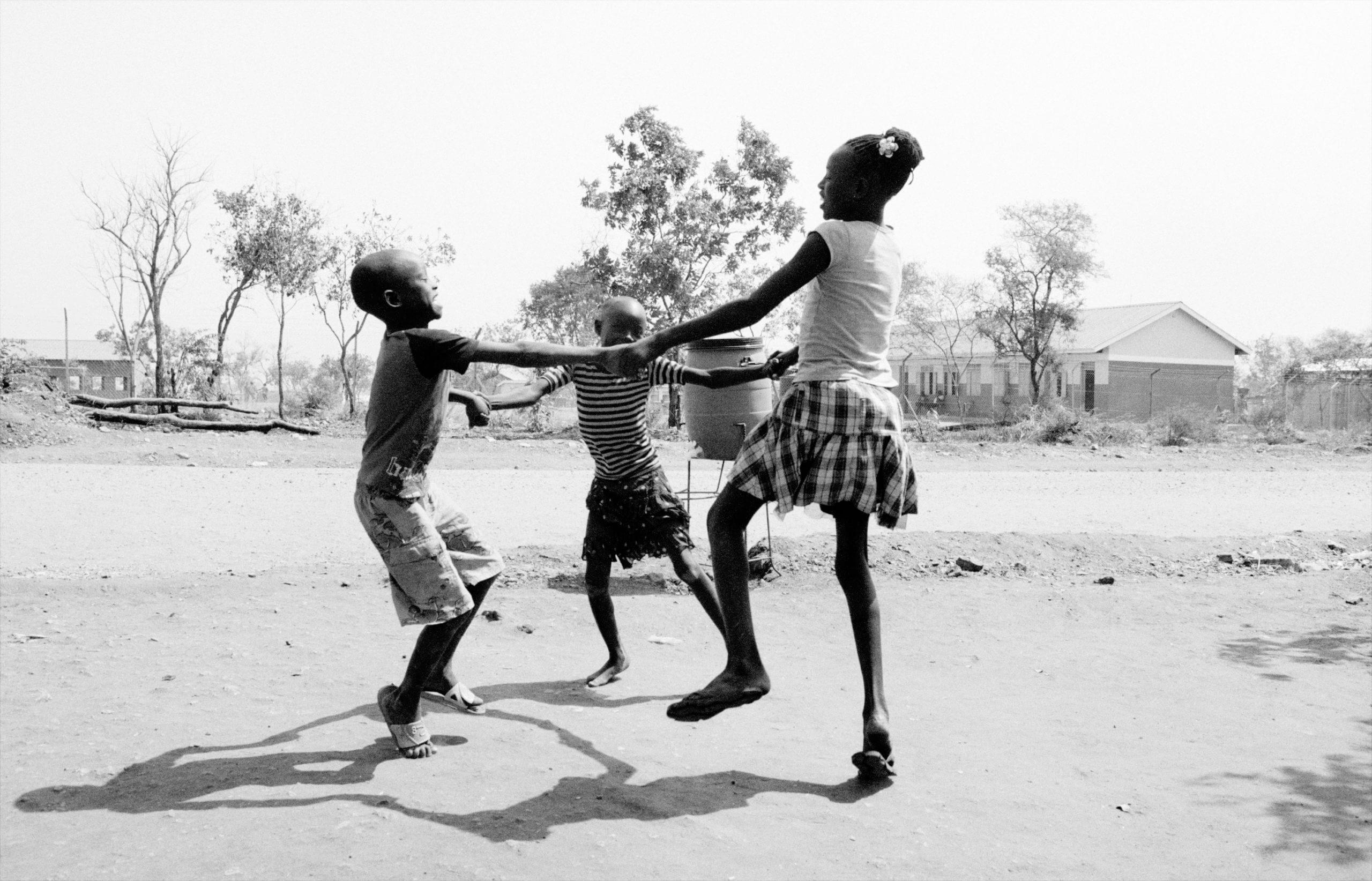 Three children dancing around in a circle